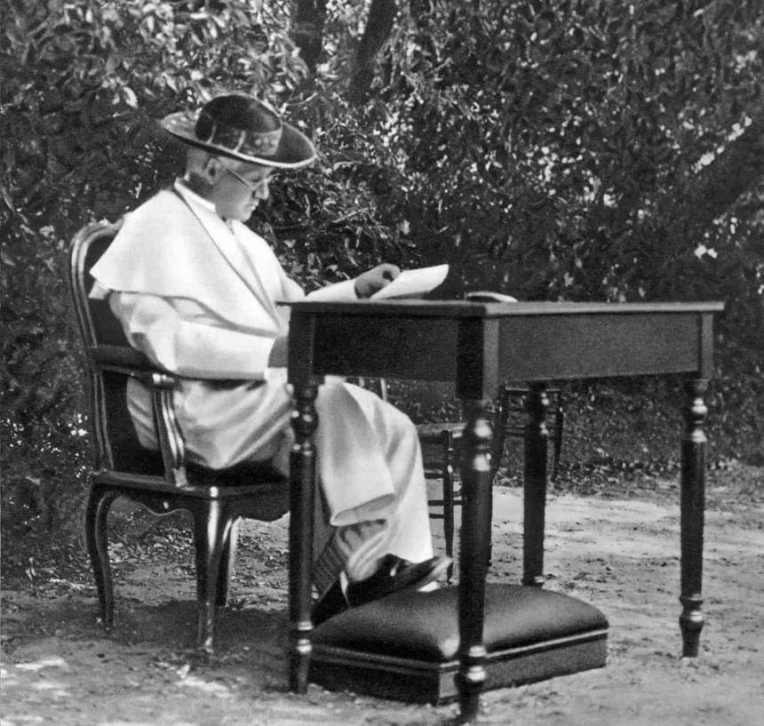 Pius X sitter ved et skrivebord i Vatikanhagen
