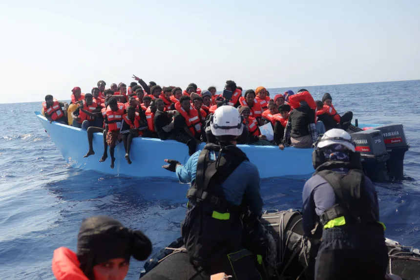 Redningspersonell nærmer seg en båt full av migranter i Middelhavet